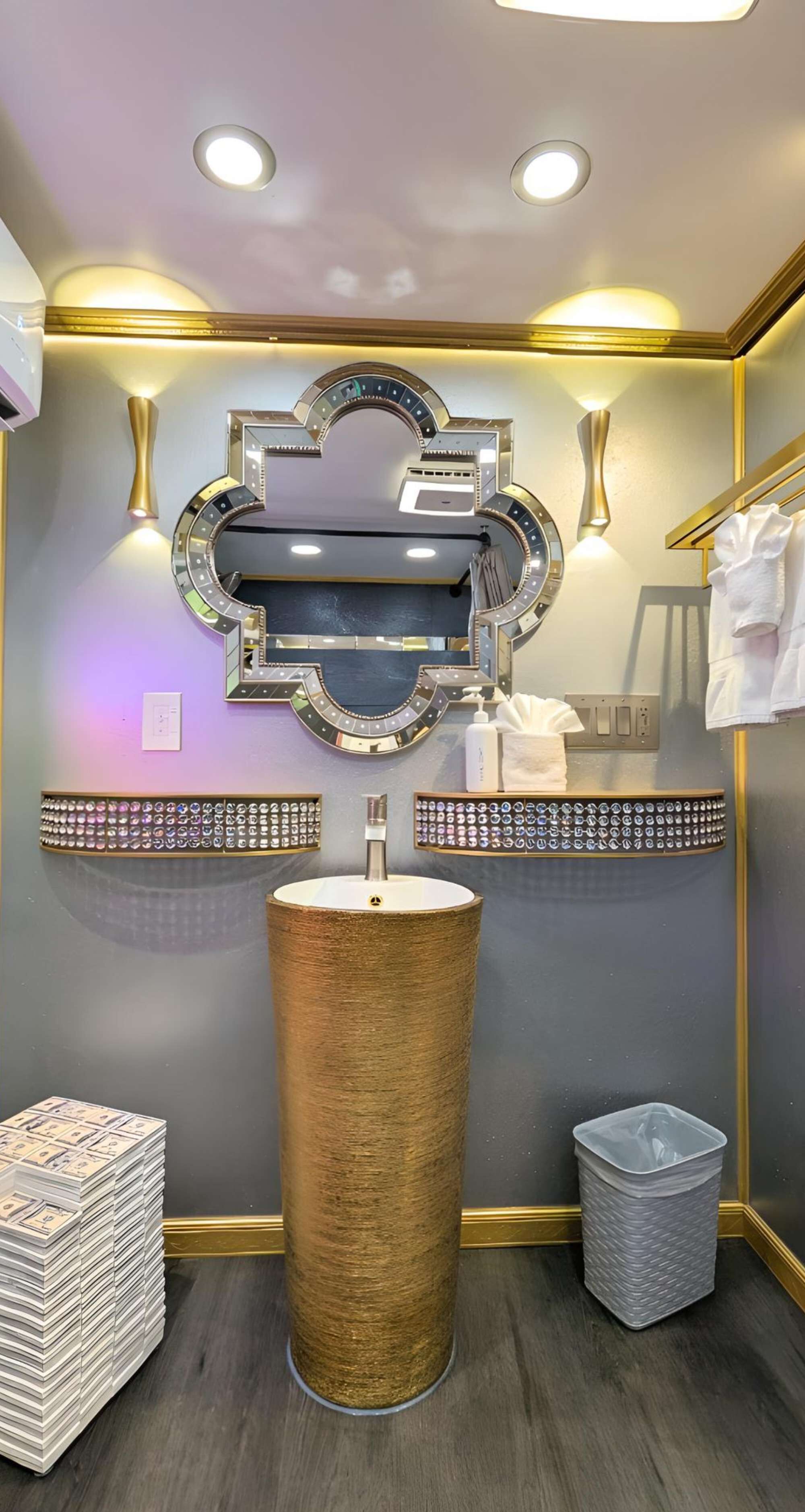 Un baño con un espejo grande, tocador y un lavabo alto y texturizado.