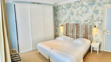 A bedroom with a bed, a nightstand, a wardrobe, and a ceiling fan.
