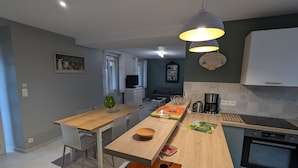 A modern kitchen with a wooden island, a coffee maker, and a built-in oven.