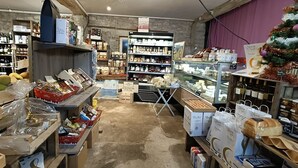 A bakery with shelves of baked goods, a display case with pastries, and a Christmas tree.
