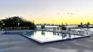Ein Dachpool mit Blick auf die Stadt bei Sonnenuntergang.