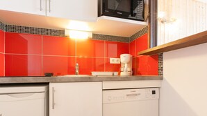 A kitchen with white cabinets, a Bosch dishwasher, a microwave, and a coffee maker.