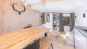 Una cocina moderna con encimeras de madera, horno integrado y un amplio ventanal con cortinas.
