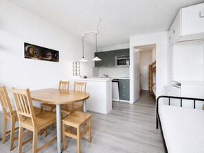 Une cuisine moderne avec un îlot central, une table à manger en bois et des chaises.