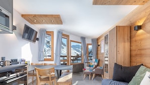 A modern kitchen with a built-in oven and a dining area with wooden chairs and a table. - Modern duplex 2/3 rooms, 6 ppl, sheets incl, Avoriaz (Avoriaz)