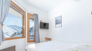 A bedroom with a bed, a TV, a window with curtains, and a framed picture on the wall. - Modern duplex 2/3 rooms, 6 ppl, sheets incl, Avoriaz (Avoriaz)