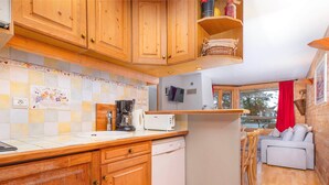 Een keuken met houten kastjes, een koffiezetapparaat, een broodrooster en een spoelbak.