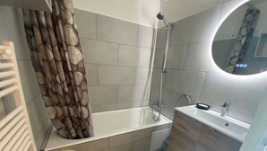 A bathroom with a bathtub, a toilet, and a sink.