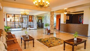 A spacious lobby with a reception desk, seating area, and a chandelier. - Lumbini Five Elements Hotel (Lumbini)