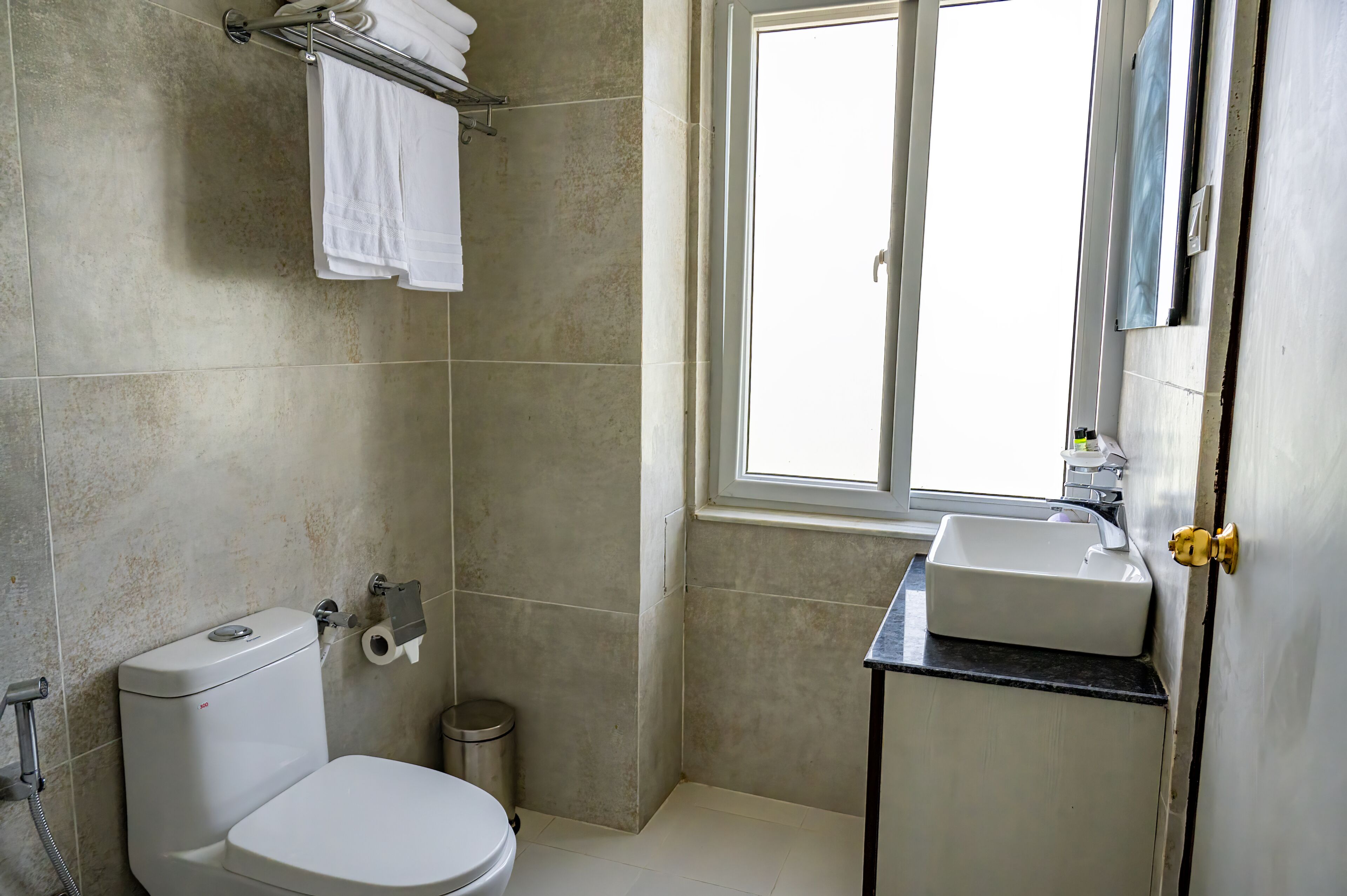 Ein Badezimmer mit Toilette, Waschbecken und Fenster.