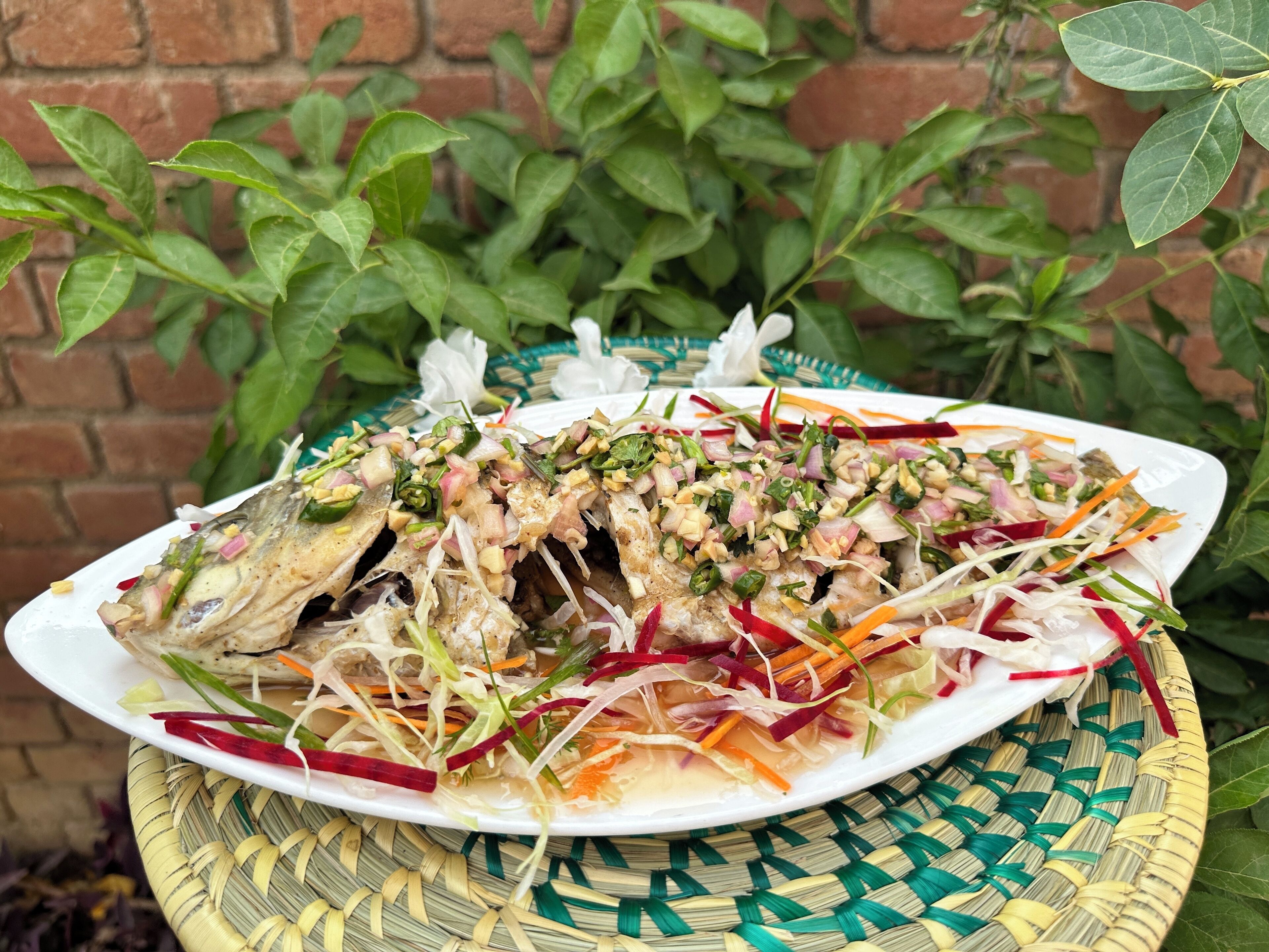 Um prato de peixe grelhado com legumes e ervas.