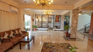 A spacious lobby with a brown sofa, wooden coffee table, and a patterned rug. - Lumbini Five Elements Hotel (Lumbini)