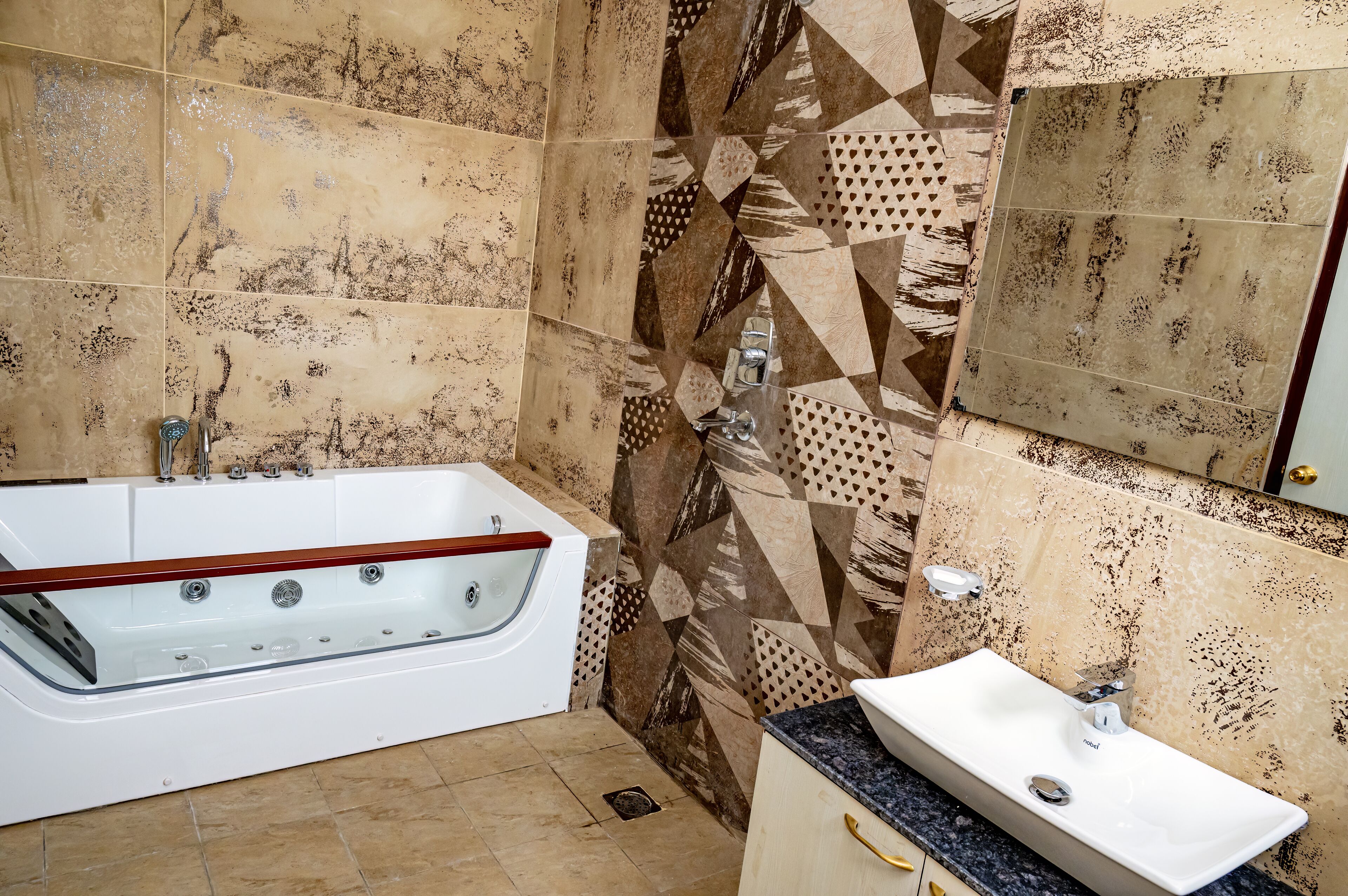 A bathroom with a freestanding bathtub, a sink, and patterned tiles.