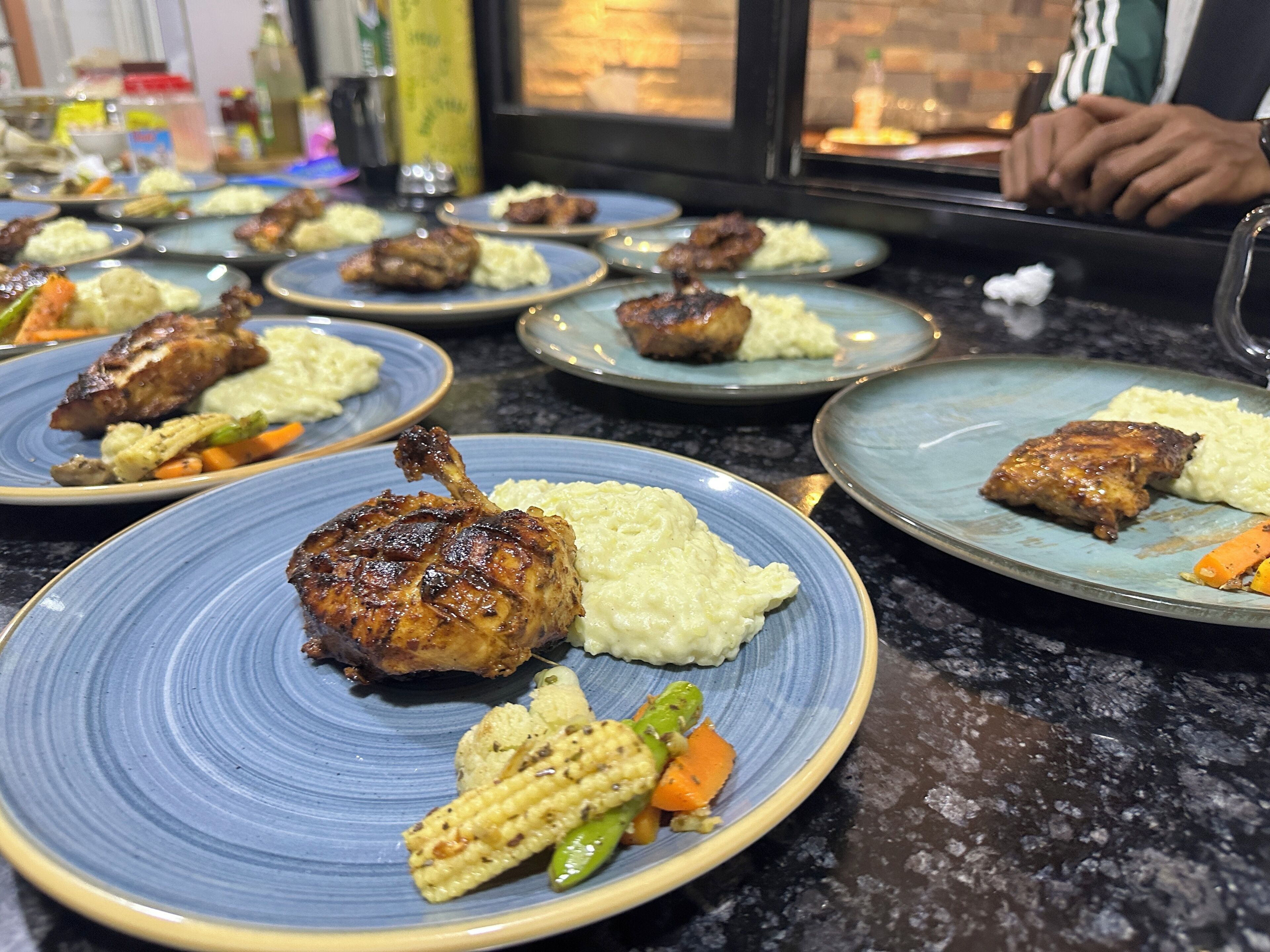 Una mesa de comedor con varios platos de comida, incluyendo carne a la parrilla y verduras.