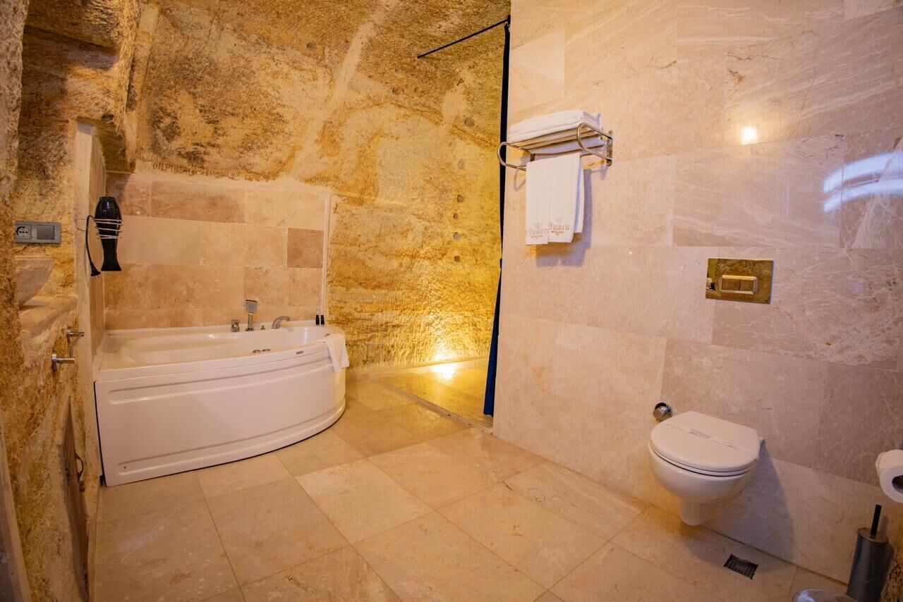 Un baño con bañera, inodoro y barra para toallas.