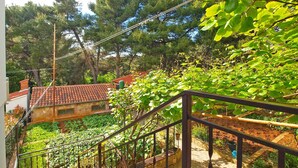 A staircase leading to a rooftop garden with a view of a house and trees. - Holiday apartment with air conditioning (Pula)