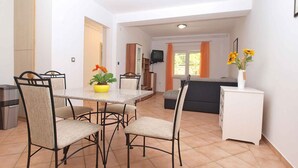 A compact living space with a dining area, kitchenette, and a sofa. - Holiday apartment with air conditioning (Pula)