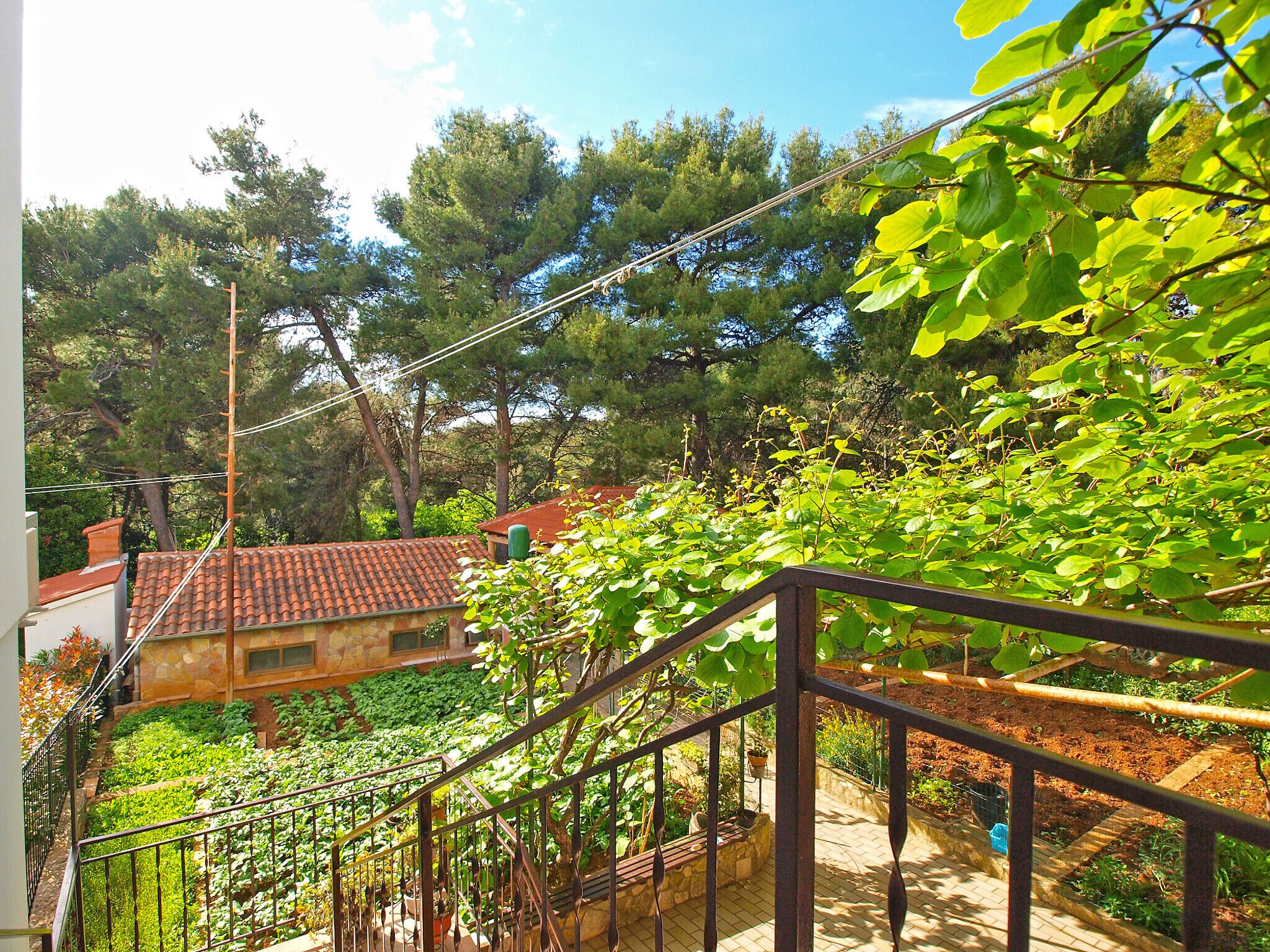 A residential area with a staircase leading to a house with a red-tiled roof.