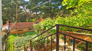 A residential area with a staircase leading to a house with a red-tiled roof. - Holiday apartment with air conditioning (Pula)