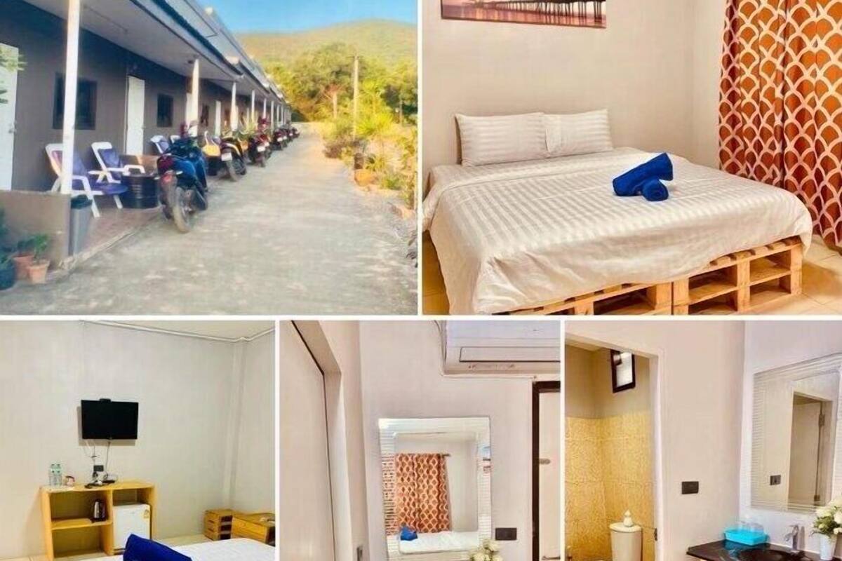 A hotel with a covered outdoor seating area, a single bed with a wooden frame, a bathroom with a wooden vanity, and a television in a room.