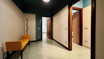 A hallway with a bench, doors, and a light fixture.