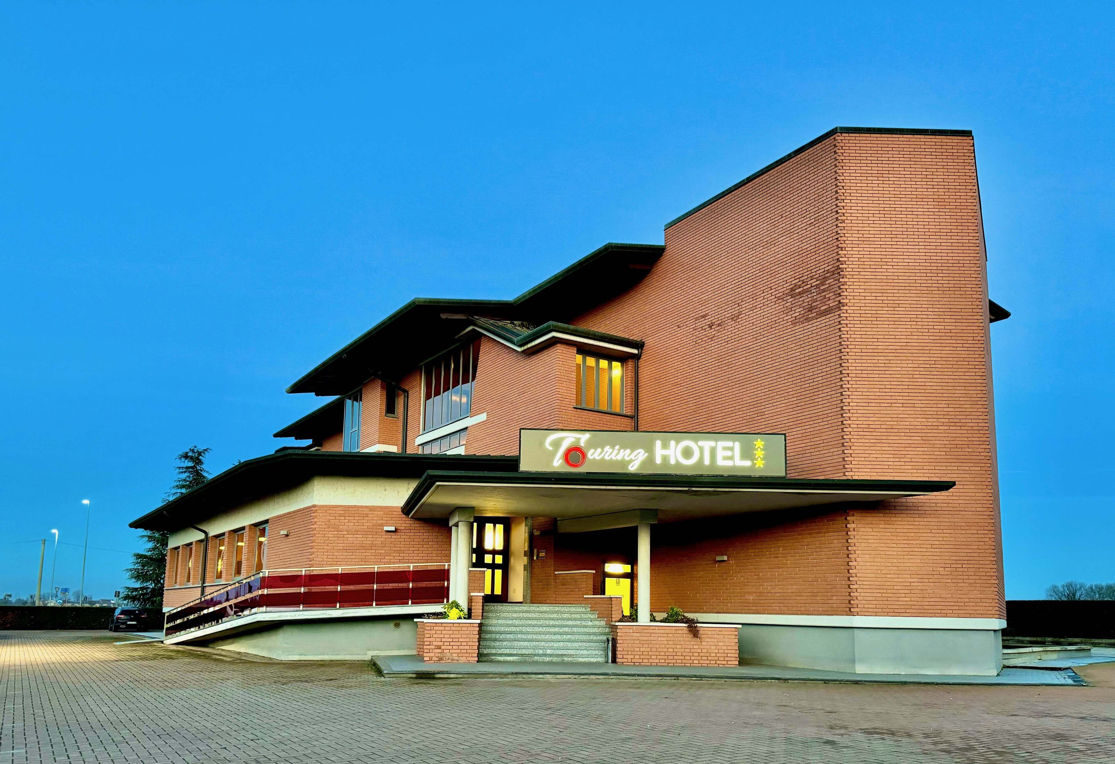 A two-story brick building with a sign reading "Curing Hotel".
