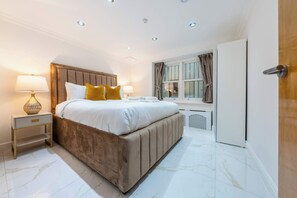 A bedroom with a bed, bedside tables, a window, and a door. - Stylish 1B Apartment with terrace in Paddington (London)