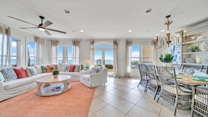 A spacious living room with a sofa set, a coffee table, and a dining area with chairs and a table. - ENDLESS VIEWS, Gulf-Front, Pool, Grill, Lg Patio, 30A, Great Location (Santa Rosa)