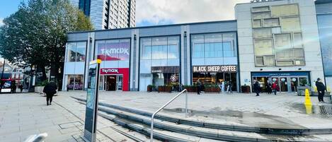 A commercial building with storefronts including 'TKMAX' and 'BLACK SHEEP COFFEE'.