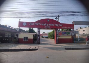 Entrada de un edificio con un letrero que dice "Rose Restaurant & Bar" y un número de contacto.