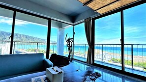A room with a large window offering a view of the sea and mountains. - Kenting Singhaiwan (Hengchun)