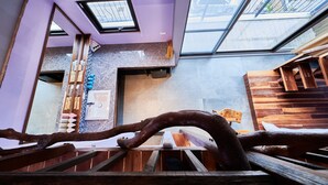 A modern interior with a skylight, wooden beams, and a stone wall. - Kenting Singhaiwan (Hengchun)