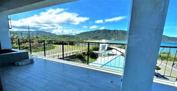 Un balcón con vistas a un paisaje montañoso y una masa de agua.