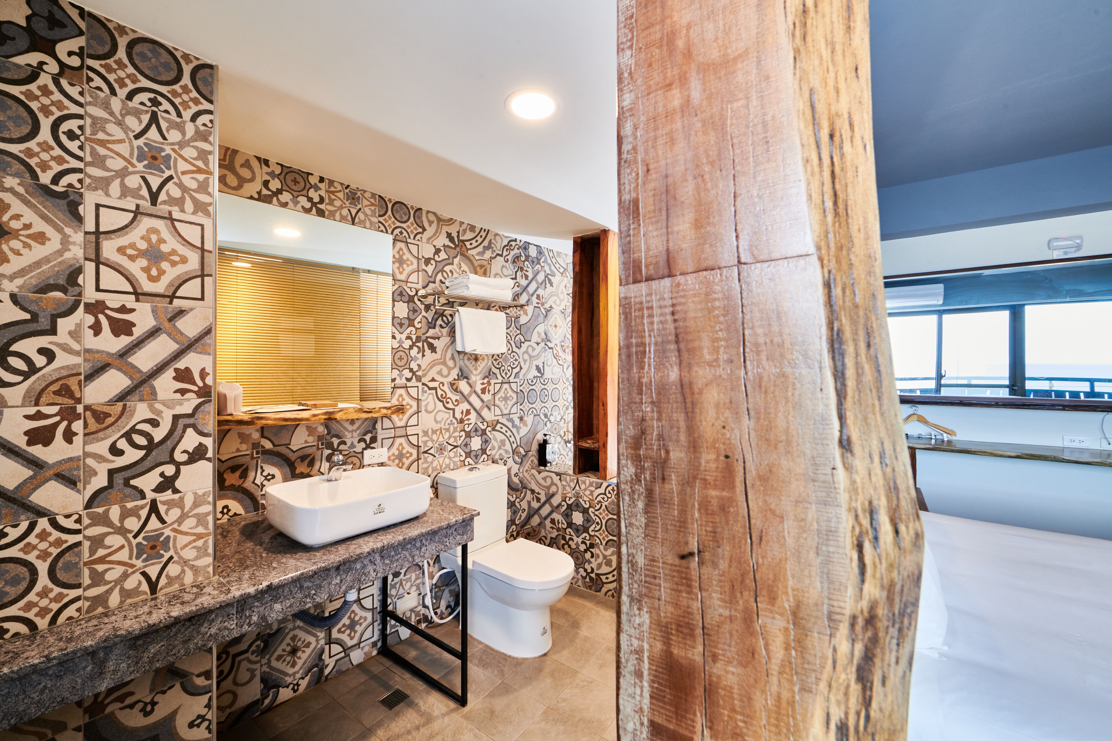 A bathroom with patterned tiles, a sink, and a toilet.