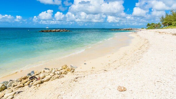 A beach with clear turquoise water, a sandy shore, and a rocky outcrop in the distance. - Bring your umbrella drinks @Tiki Beach Too! Shipyard 2bed/2bath (Key West)