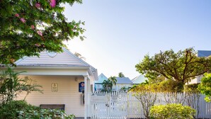 A residential property with a swimming pool, a white picket fence, and various plants. - Bring your umbrella drinks @Tiki Beach Too! Shipyard 2bed/2bath (Key West)