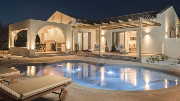 A modern house with a swimming pool, outdoor seating, and a covered patio area.