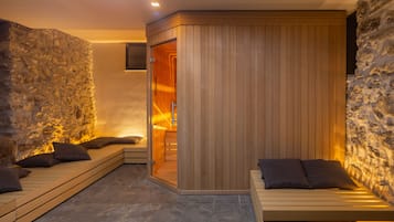 Une salle de spa avec un mur en pierre, des bancs en bois et une cloison en bois.