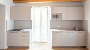 A modern kitchen with white cabinets, a microwave, and a sink. - LP4                                                                              (Orino)
