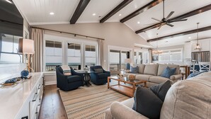 A spacious living area with a large sofa, two armchairs, a coffee table, and a ceiling fan. - New 8BR/7.5BA with Spectacular Ocean View, Elevator, Private Heated Pool (Ocean Isle Beach)