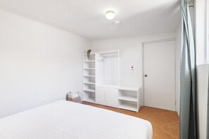 A bedroom with a bed, a wardrobe, and a door. - Private Pool! 3BR Home w Patio near Beaches, Aruba (Noord)