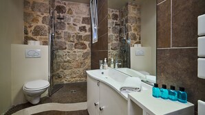Ein Badezimmer mit einer Steinsturz, einem weißen Waschbecken und einer Dusche.