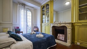 Ein Schlafzimmer mit einem großen Bett, einem Kamin und einem gelben Bücherregal.