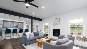 A modern living room with a gray sofa, a wooden coffee table, and a fireplace. - Stylish 4bed/4bath Retreat! (McCall)