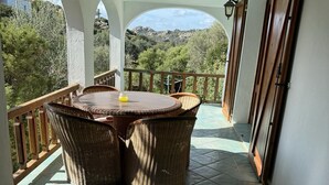 A covered patio with a round table and wicker chairs, overlooking a mountainous landscape. - 75 m² indépendant villa in Abbiadori, costa smeralda, Sardinia (Abbiadori)