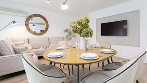 A modern dining area with a round table set for four, surrounded by chairs.