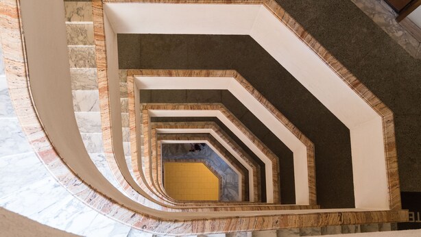 A spiral staircase with marble steps and wooden accents, leading to a lower level. - ADORABLE two-bedroom apartment close to Vatican City (Roma)