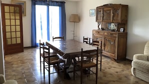 Un comedor con mesa y sillas de madera, un armario y una puerta.