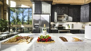 A modern kitchen with a stainless steel refrigerator, a microwave, and a large island with a variety of food items.