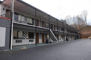 A motel with a two-story structure, a covered front porch, and a staircase leading to the upper level.
